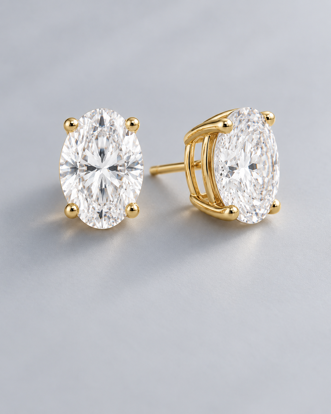 Oval moissanite solitaire stud earrings in yellow gold