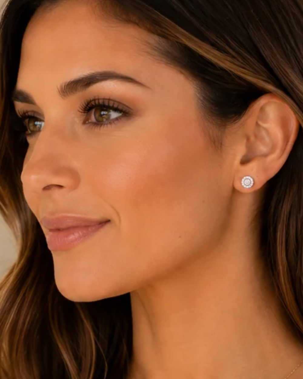 Woman wearing a halo moissanite necklace and matching halo stud earrings in white gold