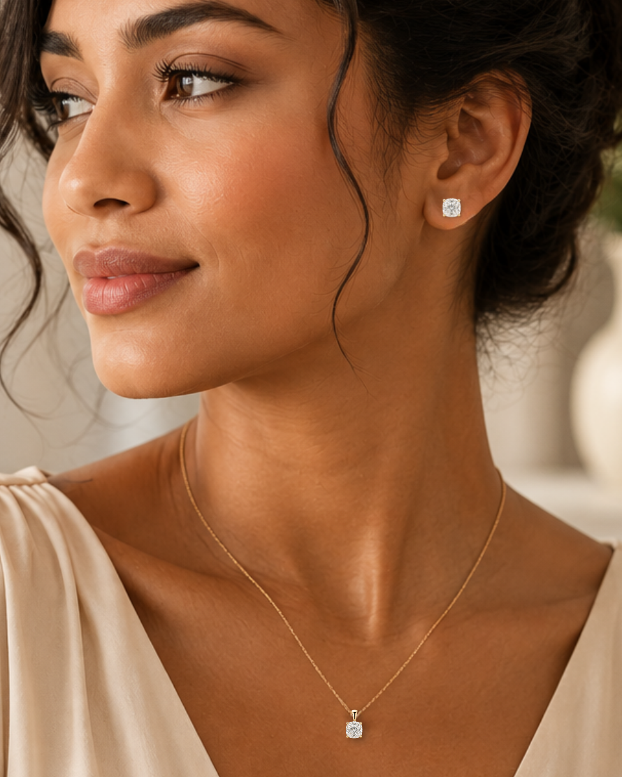 Woman wearing a cushion-cut moissanite pendant and matching stud earrings in white gold